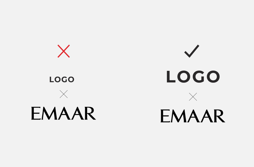 A horizontal lock-up: the Emaar wordmark beside a partner logo of matching height, divided by a rule