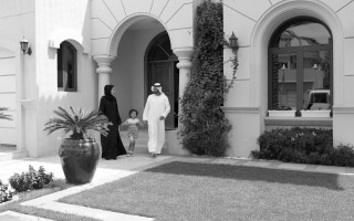 A family walking out of an Emaar villa, in black and white